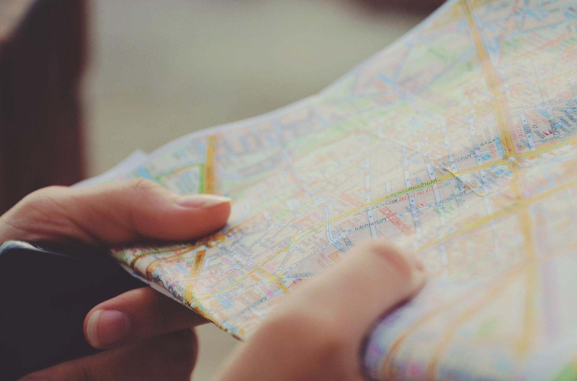 Person holding a map and a pencil.